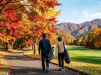 紅葉に色づいたカート道を歩くゴルファーの夫婦