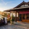 門松が飾られた正月のゴルフ場のクラブハウス入口と、並べられたキャディバッグ