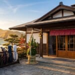 門松が飾られた正月のゴルフ場のクラブハウス入口と、並べられたキャディバッグ