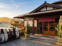 門松が飾られた正月のゴルフ場のクラブハウス入口と、並べられたキャディバッグ